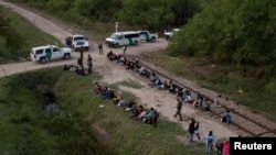 Decenas de inmigrantes con situación irregular procedentes de Rumanía, Armenia y Centroamérica son detenidos por las autoridades estadounidenses al pasar el Río Grande desde México a la localidad La Joya, en Texas, EE. UU., el 5 de mayo de 2021.