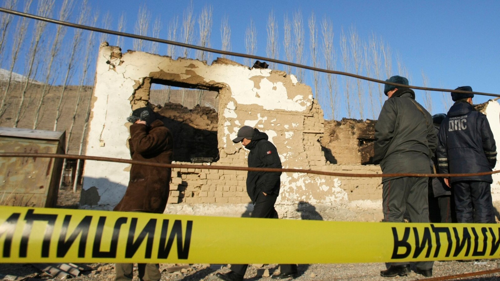 FILE - Security personnel inspect the site of a raid in the village of Besh-Kungei outside Bishkek, Kyrgyzstan, conducted as part of a military operation against suspected Islamist militants, Jan. 6, 2011.