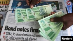 FILE:A street vendor poses with new bond notes in the capital Harare, Zimbabwe, November 28, 2016. REUTERS/Philimon Bulawayo - RTSTN0S