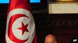 Newly elected Tunisian President Kais Saied puts his hand on the Quran to be sworn in as Tunisian President , in Tunis, Oct.23, 2019. 