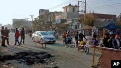 Petugas polisi berjaga di lokasi di mana seorang warga Sri Lanka digantung oleh massa Muslim di luar sebuah pabrik di Sialkot, Pakistan, 3 Desember 2021. (Foto: AP/Shahid Akram)