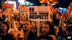 People protest in front of the Parliament building in Skopje, Macedonia, March 21, 2017. Tens of thousands of demonstrators gathered to protest a visit by a European Union envoy who is trying to break the political deadlock that has left the country without a government for three months. 