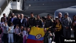 La gente está con el Ministro de Defensa de Colombia, Ivan Velázquez, y el Ministro de Relaciones Exteriores, Luis Gilberto Murillo, frente a un vuelo humanitario que llegó desde el Líbano, a la base aérea militar de CATAM, en Bogotá, Colombia, el 3 de octubre de 2024. REUTERS