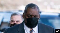 El secretario de Defensa Lloyd Austin llega al Pentágono, seguido por el jefe del estado mayor conjunto, general Mark Milley, el viernes 22 de enero de 2021.