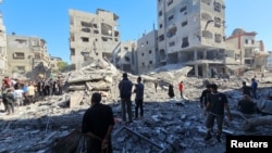 Palestinians gather at the site of Israeli strikes on houses and residential buildings, in Beit Lahiya, in the northern Gaza Strip, Oct. 20, 2024.