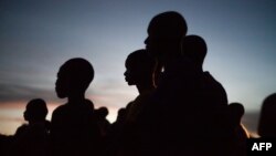 Des jeunes gens à la nuit tombée à Bayanga en République Centrafricaine le 2 novembre 2018. 