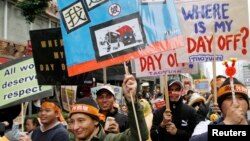 Para demonstran membawa poster-poster dalam unjuk rasa yang digelar para pekerja migran asal Filipina, Indonesia, Vietnam, dan Thailand di Taipei, 11 Desember 2011. (Foto: Reuters/dok)