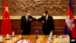 Chinese Foreign Minister Wang Yi, left, greets with Cambodian counterpart Prak Sokhonn in Phnom Penh, Cambodia, Sept. 12, 2021.
