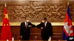 Chinese Foreign Minister Wang Yi, left, greets with Cambodian counterpart Prak Sokhonn in Phnom Penh, Cambodia, Sept. 12, 2021.