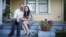 FILE - Hai Nguyen, 37 and her husband Jon Pope, 37, sit outside their home in Houston.