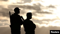 FILE - Police officers stand guard during a political rally addressed by Zimbabwe president Robert Mugabe (not pictured) in Bindura, north of the capital Harare, July 8, 2016. 