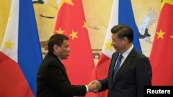 លោក​ប្រធានាធិបតី​ហ្វីលីពីន Rodrigo Duterte (រូប​ឆ្វេង) ចាប់​ដៃ​លោក​ប្រធានាធិបតី​ចិន Xi Jinping បន្ទាប់​ពី​ពិធី​ចុះ​ហត្ថលេខា​ដែល​ធ្វើ​ឡើង​នៅ​ក្នុង​ក្រុង​ប៉េកាំង ប្រទេស​ចិន កាលពី​ថ្ងៃទី២០ ខែតុលា ឆ្នាំ២០១៦។