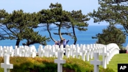 在诺曼底登陆纪念日，人们前往法国西部的美军公墓凭吊。