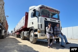 Truk-truk yang membawa bantuan kemanusiaan antre di sisi Mesir di perbatasan Rafah dengan Jalur Gaza pada 2 Maret 2025, setelah Israel menangguhkan masuknya pasokan ke wilayah Palestina. (Foto: AFP)