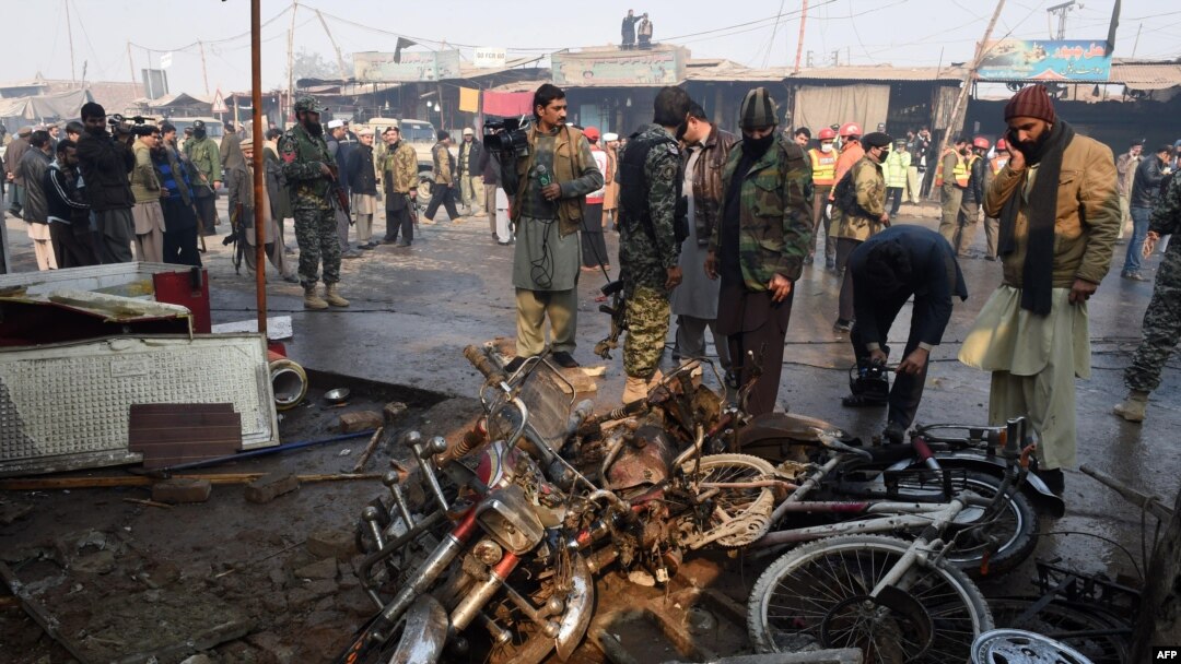 Petugas keamanan Pakistan memeriksa lokasi ledakan bom di Peshawar (19/1).