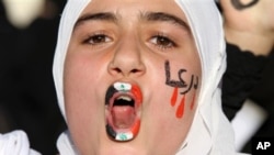 With a Syrian flag painted on her lips and Arabic writing that reads: "Daraa" on her cheek, a Syrian girl shouts slogans during a demonstration demanding that Syria's President Bashar Assad steps down, in front of the Syrian Embassy in Amman, Jordan, Sun