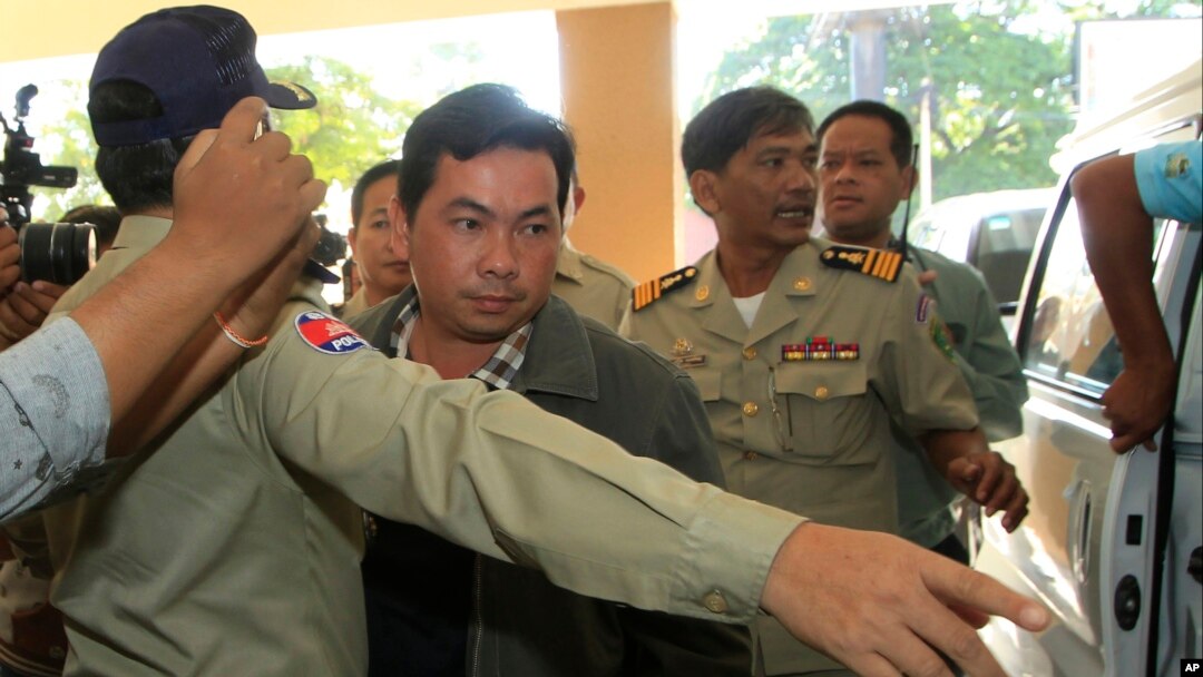 Ông Chay Sarith (giữa), một nghi phạm tấn công bị cáo buộc đánh đập hai nhà lập pháp đối lập cùng với hai người khác, đang bị áp giải bởi cảnh sát tại tòa án Phnom Penh, Campuchia, thứ Tư ngày 4/11/2015.