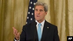 U.S. Secretary of State John Kerry, gestures as he speaks to the media during a joint press conference with Qatari Foreign Minister Khaled Al Attiyeh after a meeting with the Arab League in Paris, Oct. 21, 2013. 