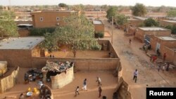 FILE - People walk in a courtyard in Niamey, Niger, Feb. 16, 2016. 