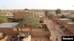 FILE - People walk in a courtyard in Niamey, Niger, Feb. 16, 2016. A fire at a school in the Pays Bas neighborhood on April 13, 2021, left at least 20 children dead.