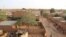 FILE - People walk in a courtyard in Niamey, Niger, Feb. 16, 2016. A fire at a school in the Pays Bas neighborhood on April 13, 2021, left at least 20 children dead.