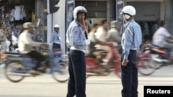 In this photo taken on Nov. 2, 2002, Cambodian police redirect traffic in Phnom Penh, Cambodia.