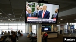 President Donald Trump is pictured on a television at Seattle-Tacoma International Airport as he declares a national emergency over the coronavirus, in SeaTac Washington, March 13, 2020. 