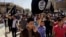 FILE - Demonstrators chant pro-Islamic State group slogans as they carry the group's flags in front of the provincial government headquarters in Mosul, Iraq, June 16, 2014.