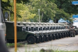 FILE - Troops are seen by a row of over a dozen army jeeps at the Shek Kong military base of People's Liberation Army in New Territories, Hong Kong, China, Aug. 29, 2019.