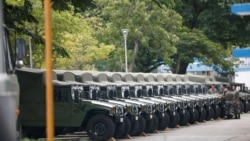 FILE - Troops are seen by a row of over a dozen army jeeps at the Shek Kong military base of People's Liberation Army in New Territories, Hong Kong, China, Aug. 29, 2019.