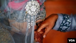 Seorang perempuan mencium tangan suaminya setelah akad nikah di sebuah masjid di Banda Aceh, 9 Desember 2012. (Foto: Reuters) 