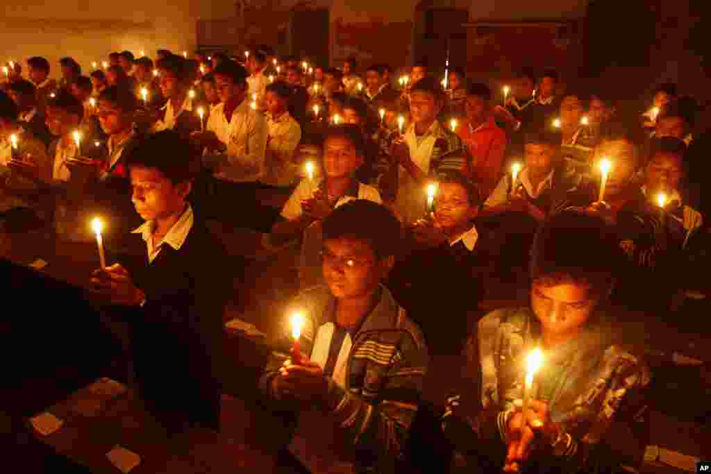 Para siswa di India menyalakan lilin untuk menghomati Ravi Shankar di bekas sekolah Shankar, Bengali Tola Inter College, India (12/12). (AP/Rajesh Kumar Singh)