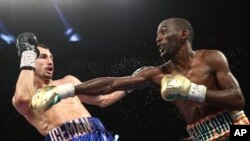 Terence Crawford, à droite, frappe son adversaire Viktor Postol lors de la compétition WBC-WBO à Las Vegas, le 23 juillet 2016.