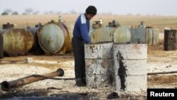 FILE - The Islamic State is funded, in part, through oil. Here, a youth works at a makeshift oil refinery in Syria that, according to its owner, gets the crude oil from Islamic State-controlled areas of Syria and Iraq.