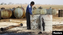 A youth works at a makeshift oil refinery in Syria that, according to its owner, gets crude oil from Islamic State-controlled areas of Syria and Iraq.