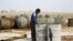 FILE - A youth works at a makeshift oil refinery in Syria that, according to its owner, gets the crude oil from Islamic State-controlled areas.