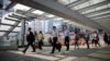 FILE - Government employees arrive to work at an area occupied by protesters outside of the government headquarters building in Hong Kong, Oct. 6, 2014. Chinese civil servants are experiencing pay cuts as the country recovers from COVID-related lockdowns. 