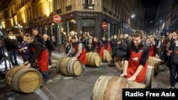 Men roll barrels of Beaujolais Nouveau wine for the official launch of the 2015 vintage in the center of Lyon early November 19, 2015. 