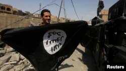 A member of Iraqi Counter Terrorism Service holds an Islamic State militants as he celebrates in the Old City of Mosul, Iraq July 9, 2017. 