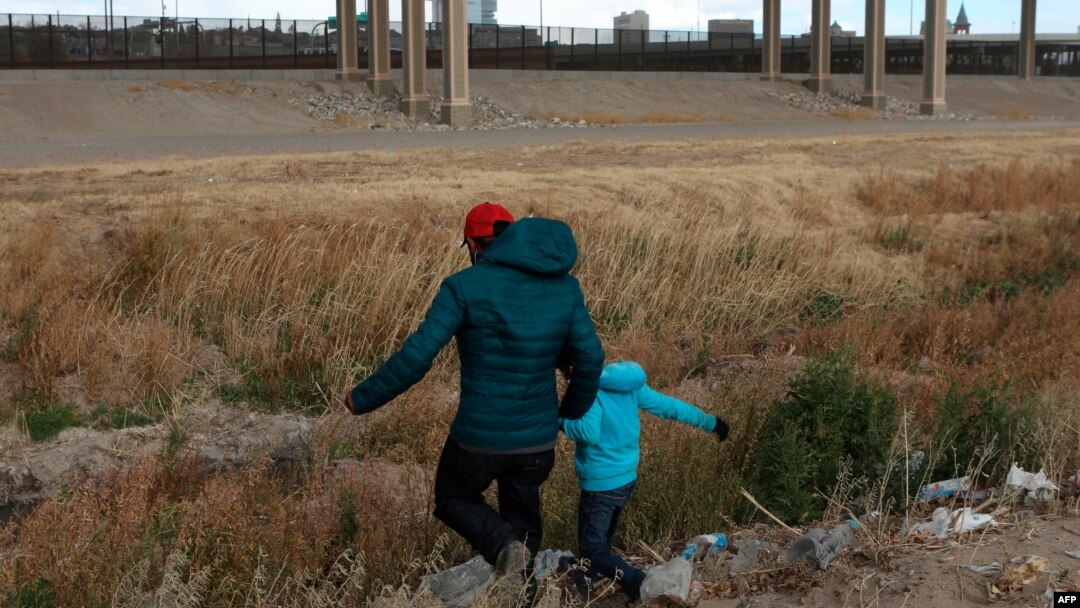 Migrant iz Gvatamale sa sinom prelazi reku Rio Grande, prirodnu granicu između El Pasa u državi Teksas i Kjudad Huareza, u državi Čivava u Meksiku, u potrazi za političkim azilom, 26. januara 2021. (Photo by HERIKA MARTINEZ / AFP)