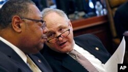 Mississippi state Sen. Eugene "Buck" Clarke, right, confers with Sen. Robert Jackson, Feb. 5, 2019, in Jackson, Miss. Clarke's district is to be redrawn by order of a federal appeals court. Clarke is not seeking re-election.