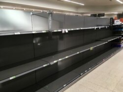 Shelves stand empty in the aisle for toilet rolls, after panic buying as result of the coronavirus, in a branch of the Waitrose supermarket in Surbiton, south west London, March 11, 2020.