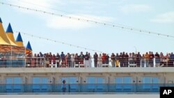 FILE - Passengers of the Costa Deliziosa cruise ship wait to disembark in the port of Genoa, Italy, April 22, 2020.