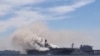 Asap mengepul dari kebakaran di kapal serbu amfibi Angkatan Laut AS USS Bonhomme Richard di Pangkalan Angkatan Laut San Diego, California, pada 12 Juli 2020. Video kebakaran ini secara keliru dikaitkan dengan serangan Houthi di Laut Merah.