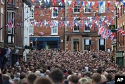 The ball is thrown high above the crowd during the annual Shrovetide medieval football match played in Ashbourne, England, March 4, 2025.