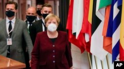 Kanselir Jerman Angela Merkel dan rombongan meninggalkan ruang pertemuan KTT Uni Eropa di Brussels, Belgia hari Jumat (16/10).