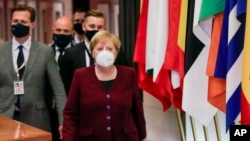 German Chancellor Angela Merkel leaves during as officials depart at the end of an EU summit in Brussels, Belgium, Oct. 16, 2020.