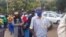 Zinbabweans wait in a long line to be vaccinated