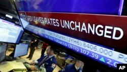 Layar televisi di New York Stock Exchange menunjukkan tingkat suku bunga bank sentral AS tidak berubah 27 Januari lalu (foto: dok). Bank sentral AS akan kembali mempertahankan tingkat suku bunga acuan.