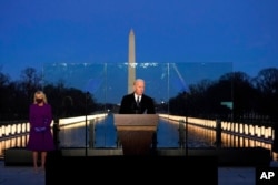 President-elect Joe Biden speaks during a COVID-19 memorial, with lights placed around the Lincoln Memorial Reflecting Pool, in Washington, Jan. 19, 2021.